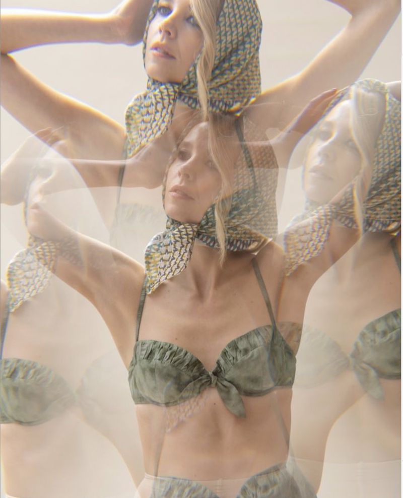 Woman with fair skin, wearing an olive-green bikini top and patterned headscarf, appears as a triple exposure in a bright, neutral studio.