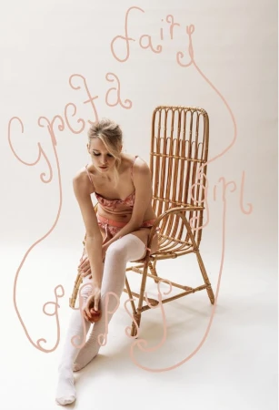 Blonde woman in lingerie sits on a cane chair holding a peach in a studio setting with artistic text effects, creating a dreamy aesthetic.