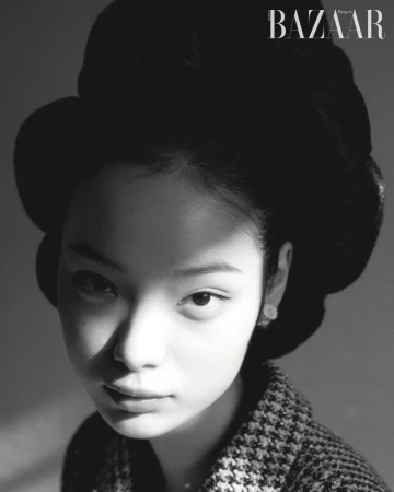 Black and white portrait of Jennie Kim with a voluminous bouffant hairstyle and houndstooth jacket for Harper's Bazaar Korea.