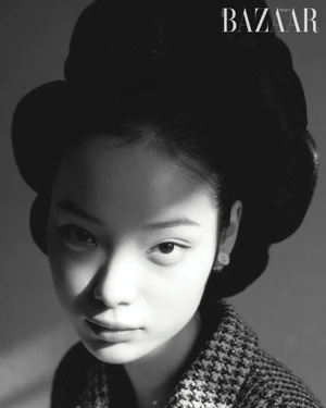 Black and white portrait of Jennie Kim with a voluminous bouffant hairstyle and houndstooth jacket for Harper's Bazaar Korea.