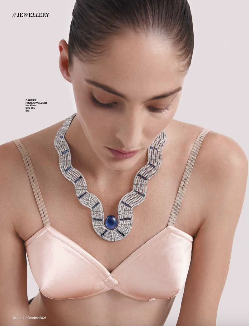 Elegant woman with blue-stone necklace. Jewellery ad featuring an adult female model wearing a diamond necklace in a studio setting.