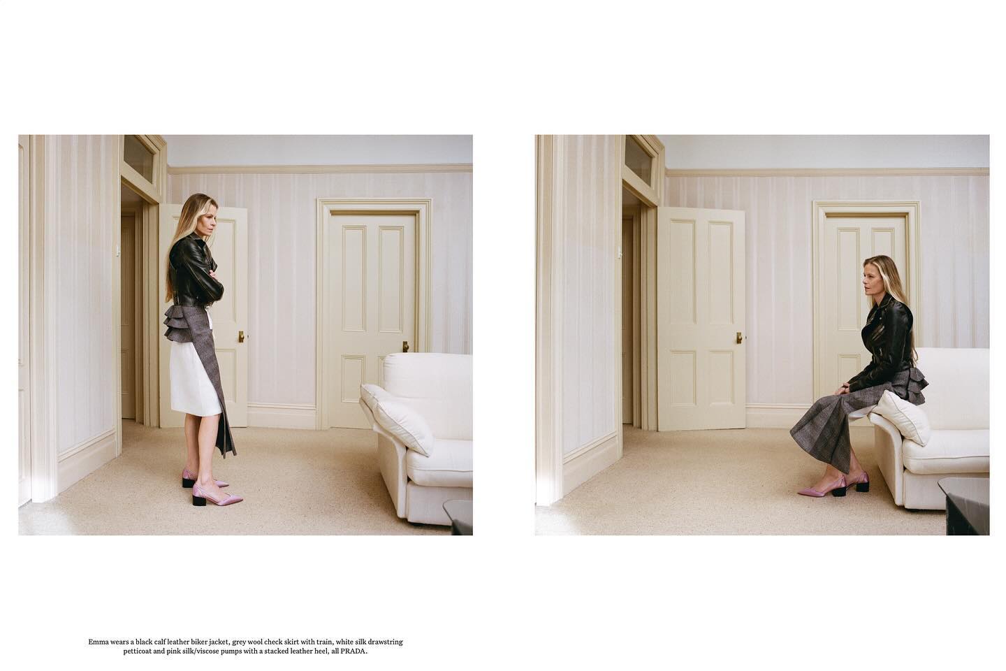 Fashion editorial shot of a blonde woman in a black leather jacket and grey wool skirt posing in an off-white room with two doors.