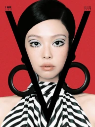 Close-up portrait of Jennie in a black and white striped halter top against a solid red background with large sculptural black earrings