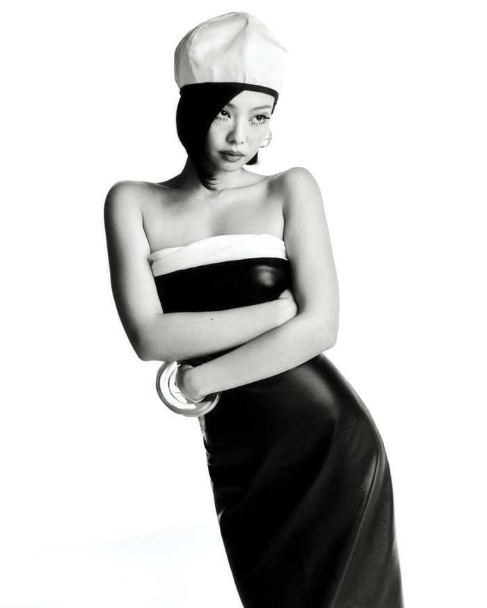 Jennie wearing a strapless black and white dress and white cap in a studio portrait for V Magazine