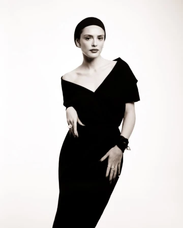 Monochrome portrait of a woman in a black dress and head wrap against a white background, showcasing fashion and studio photography.