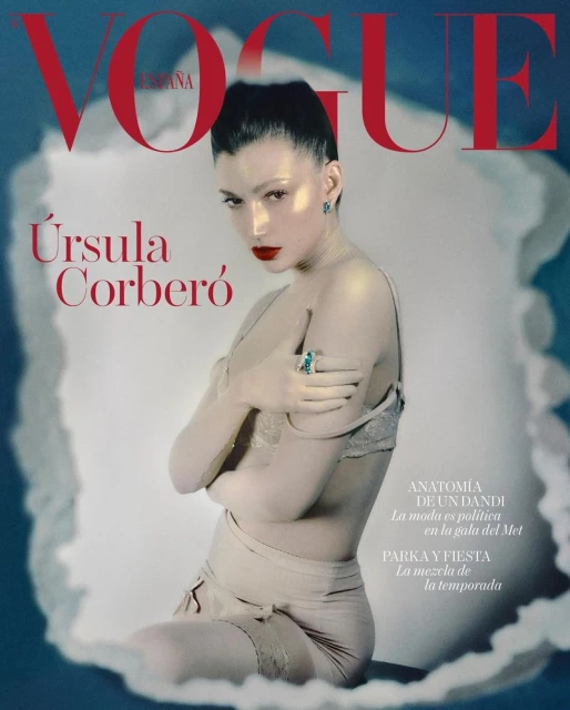 Vogue España cover featuring model Ursula Corbero with red lips, wearing lingerie and jewelry, set against a soft blue background.