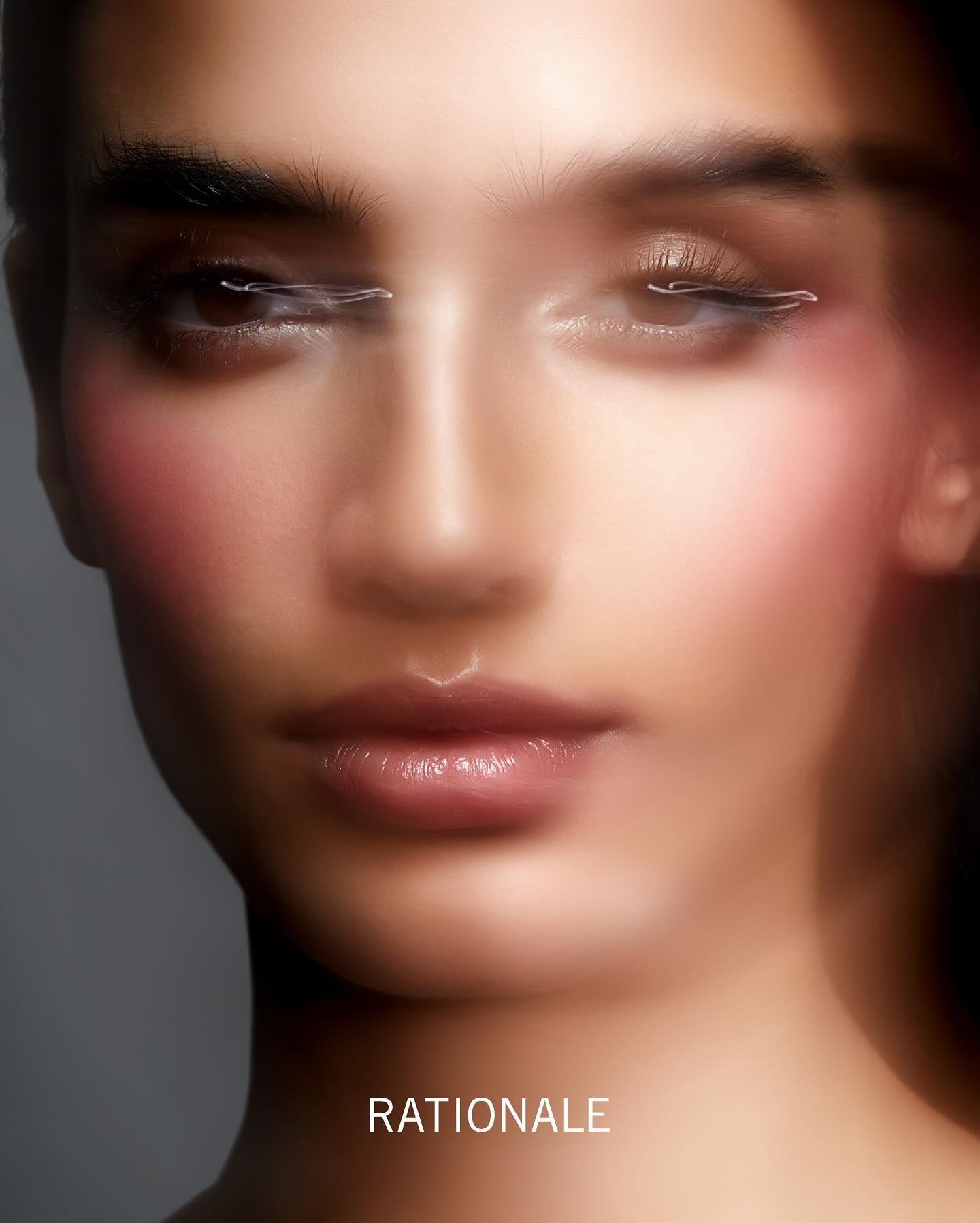 Close-up portrait of a woman with glowing skin and soft makeup for Rationale by Justin Ridler.