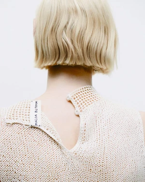 Close-up back view of a person with blonde short hair wearing a cream crochet top by Magda Butrym