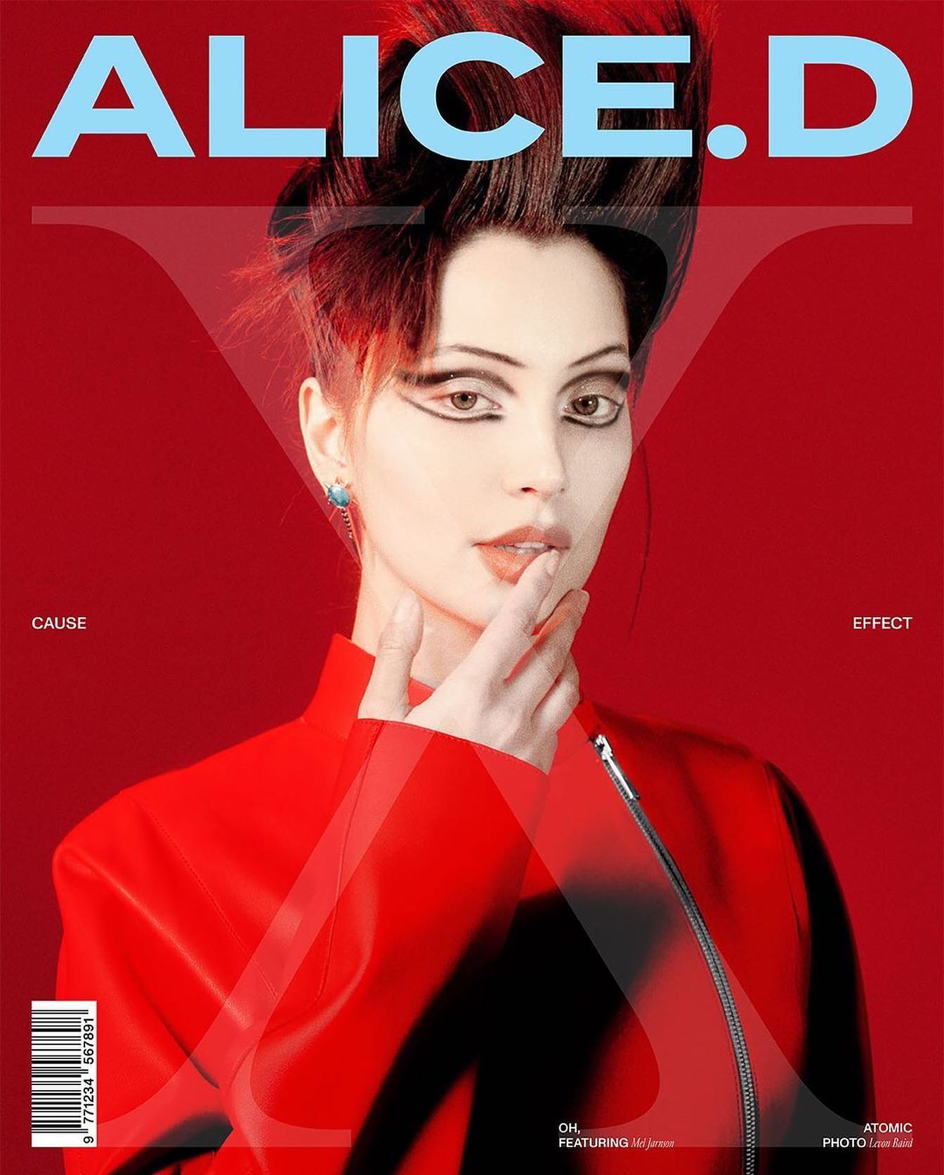 Magazine cover featuring a model with dramatic eye makeup and a red jacket against a matching red background, showcasing fashion and beauty.