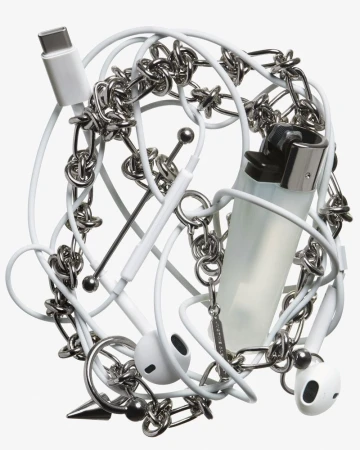 Still life of an assortment of everyday objects, including earbuds, a white USB-C cable, a lighter, and a silver metal chain.