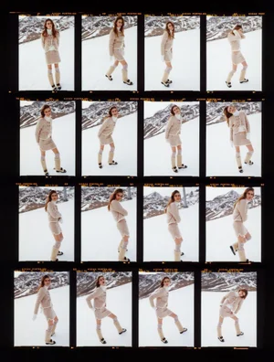 Film contact sheet of model Mia Armstrong posing on a snowy mountain slope in a beige knit skirt suit for Vogue Netherlands.