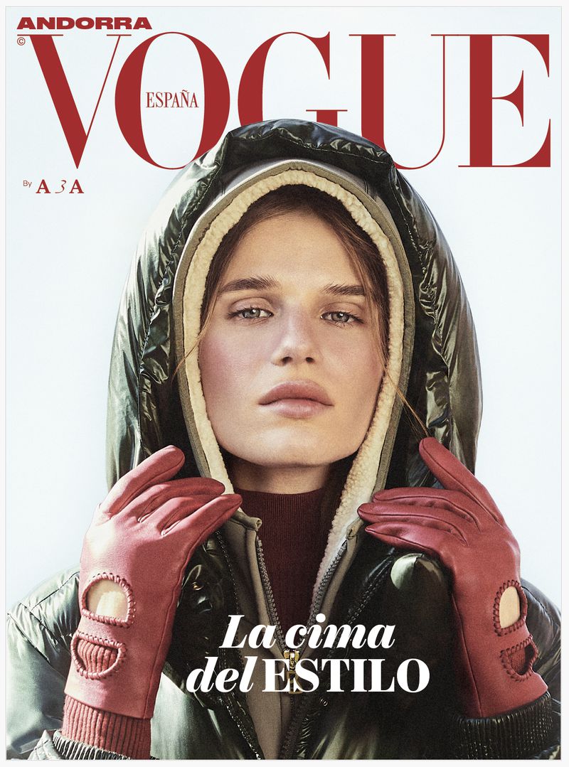 Vogue España magazine cover featuring a woman in a hooded puffer jacket and red leather gloves, set against a bright outdoor background.