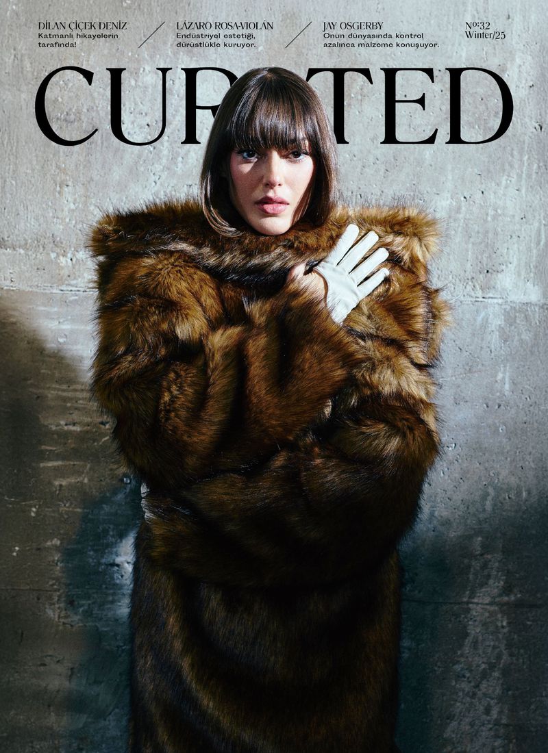 Magazine cover featuring a woman with dark hair in a fur coat and gloves, against a textured background with magazine text.