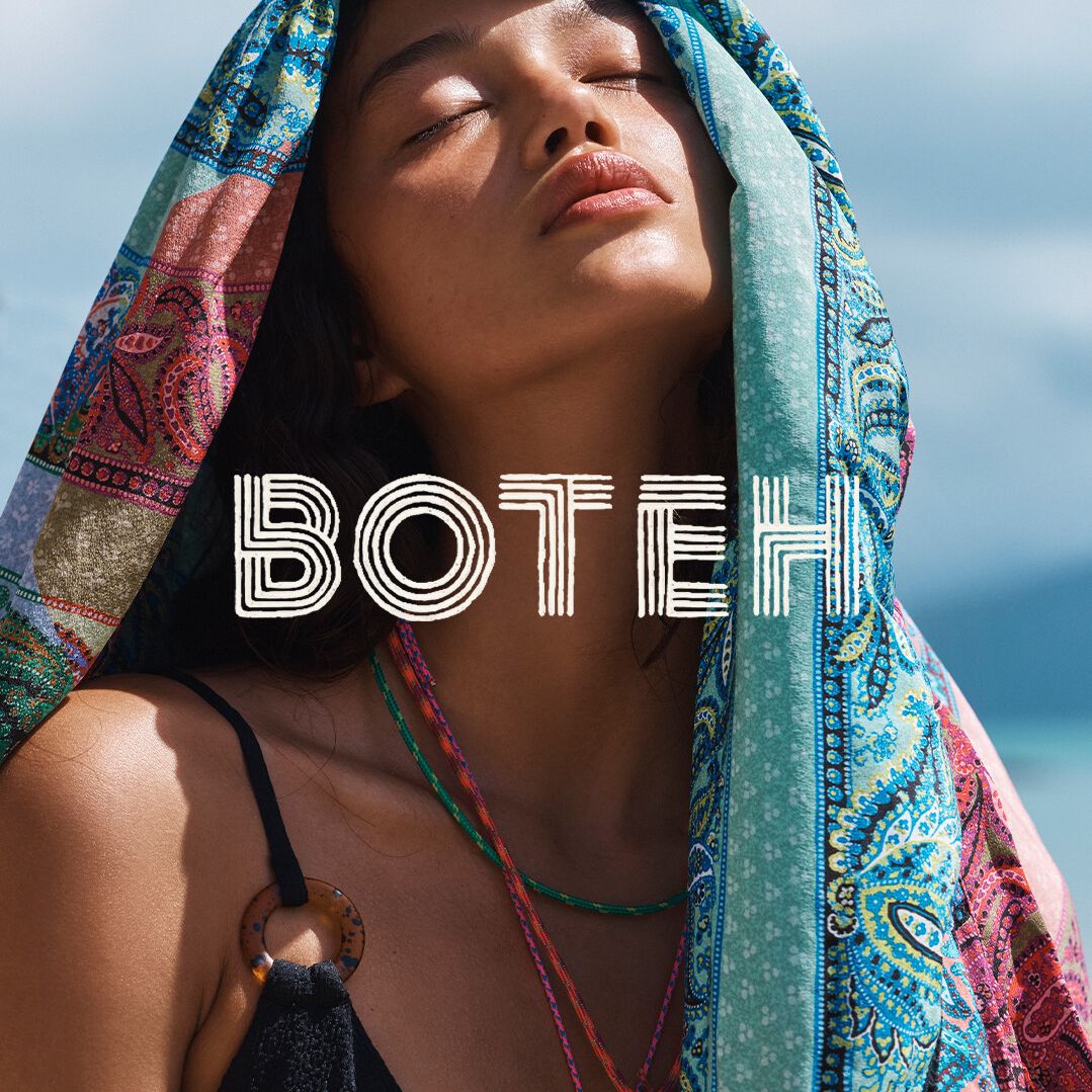 Portrait of a serene woman wearing a patterned headscarf and black tank top against a bright outdoor backdrop, fashion, beauty.