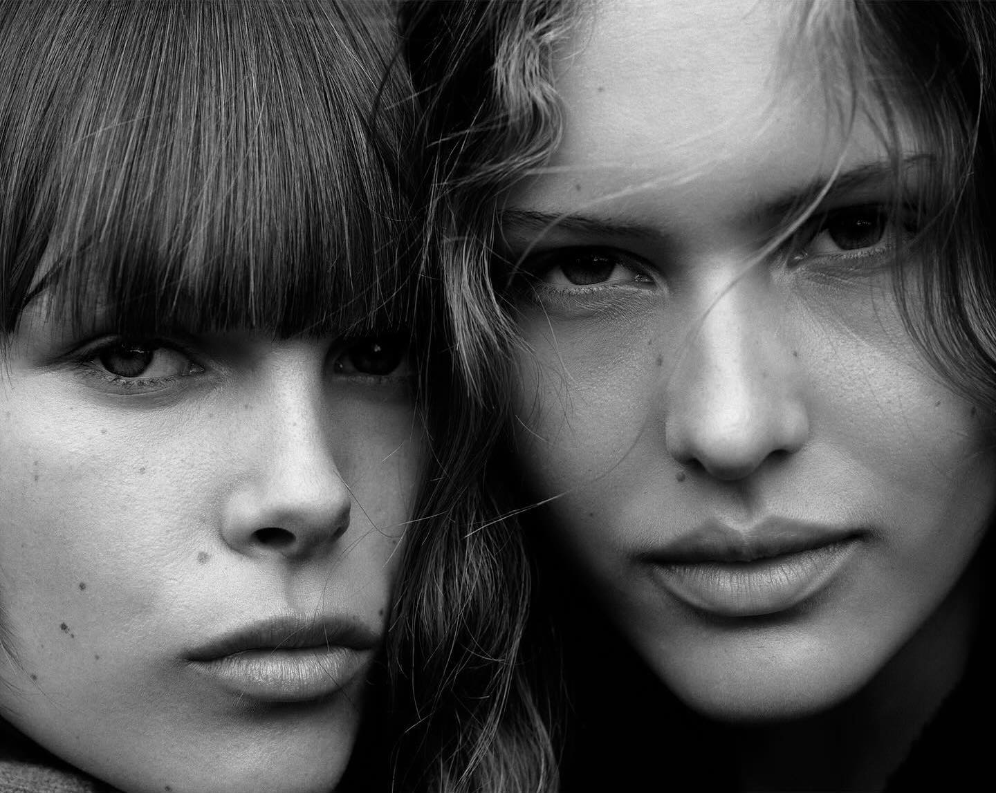 Black and white portrait of two adult women with medium length hair looking directly at the camera in a beauty or fashion setting.