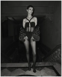 Model Chen Xi wearing PatBO F/W 24 black strapless lingerie and embellished jacket on hotel staircase