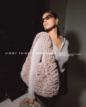 Model wearing dark angular sunglasses and ribbed top holding a ruffled textured handbag for Ester Manas
