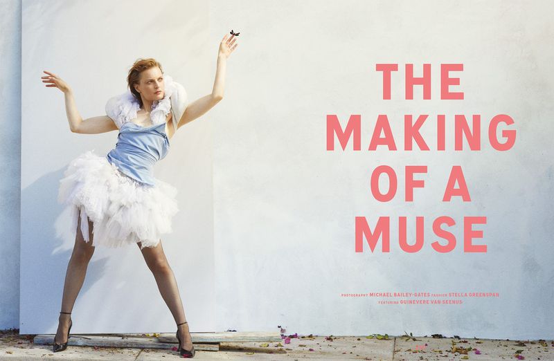 Editorial fashion shot of a woman in a light blue dress and white tutu with a large ruffle collar posing in front of a white wall.