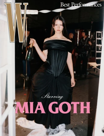 Mia Goth poses in a black dress holding a champagne bottle, on the cover of W Magazine's 'Best Performances' issue. 