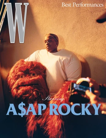 Magazine cover featuring A$AP Rocky with a furry monster puppet and a camera being pointed at him against a beige wall background.