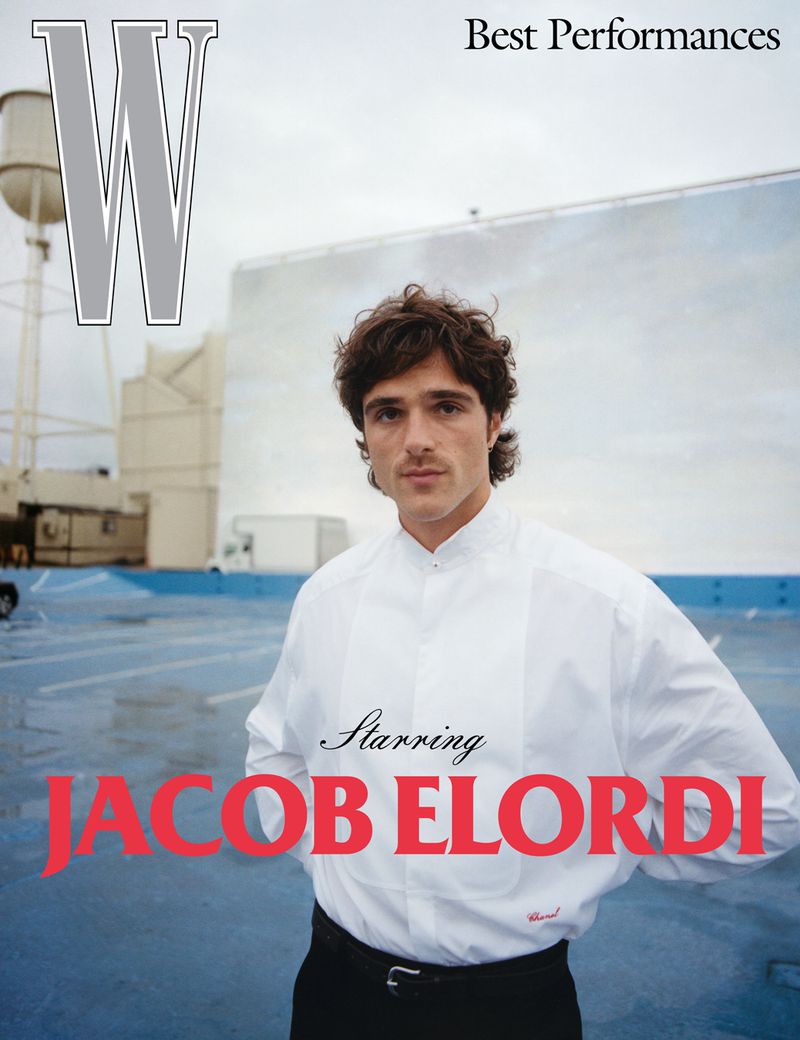 Portrait of Jacob Elordi for 'W' Magazine's Best Performances, wearing a white shirt and black pants, against a reflective backdrop.