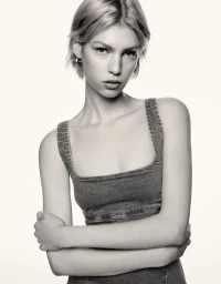 Model with short blonde hair wearing a square-neck denim dress against a plain white background for Bershka