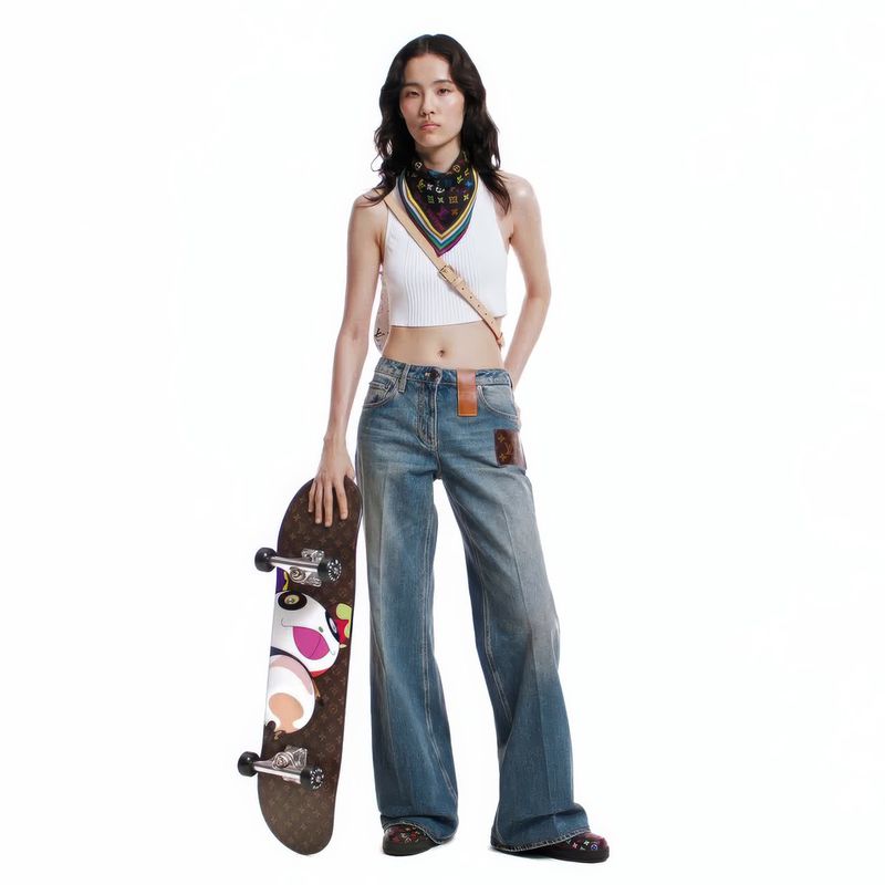 A full-length shot of an Asian woman in light wash denim and a white ribbed top, holding a skateboard against a white backdrop.