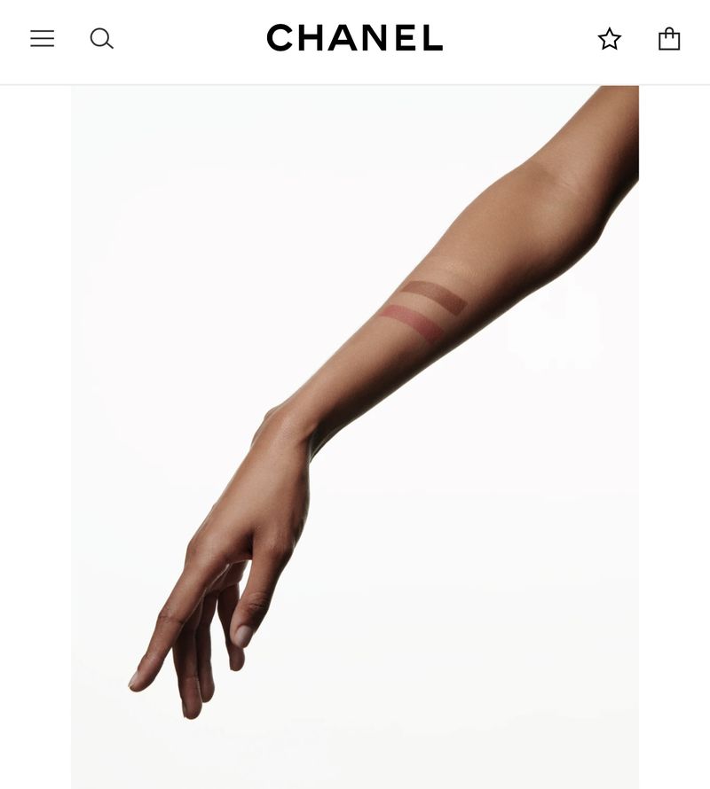 Arm with makeup swatches against a bright white background. Beauty advertisement featuring a female arm.