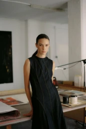 Model in a dark denim dress posing in a studio interior for Ulanka Pre-fall 2024 Collection