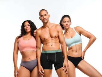 Three models posing in athletic underwear and sports bras against a bright white background for Reebok.