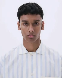 Portrait of a man wearing a white and blue striped collared shirt against a plain white studio background.
