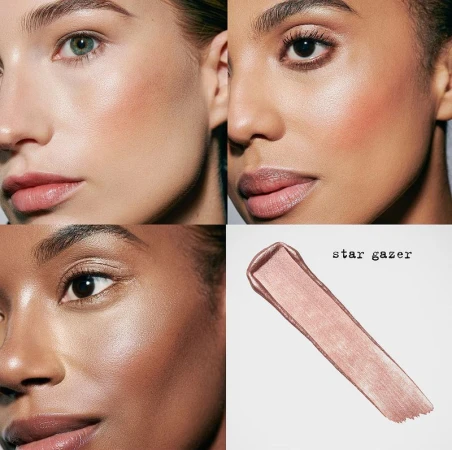 Close-up of three diverse women showcasing makeup with a smear of shimmering pink highlighter on a gray background.