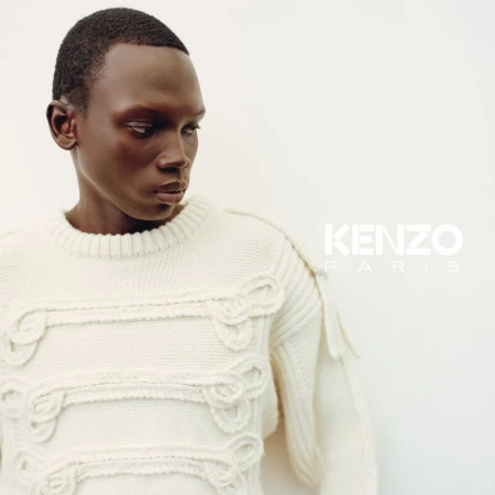 Black man wearing a textured cream knit sweater against a plain white studio background for Kenzo