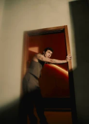 Ar<span></span>ón Piper leaning against a doorway in a sleeveless vest for Fucking Young, photographed by Louis Teran.