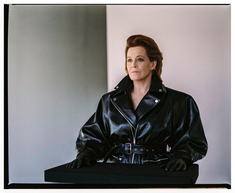Portrait of mature woman in a black leather jacket. She has medium brown hair and fair skin. Neutral background. Studio lighting.