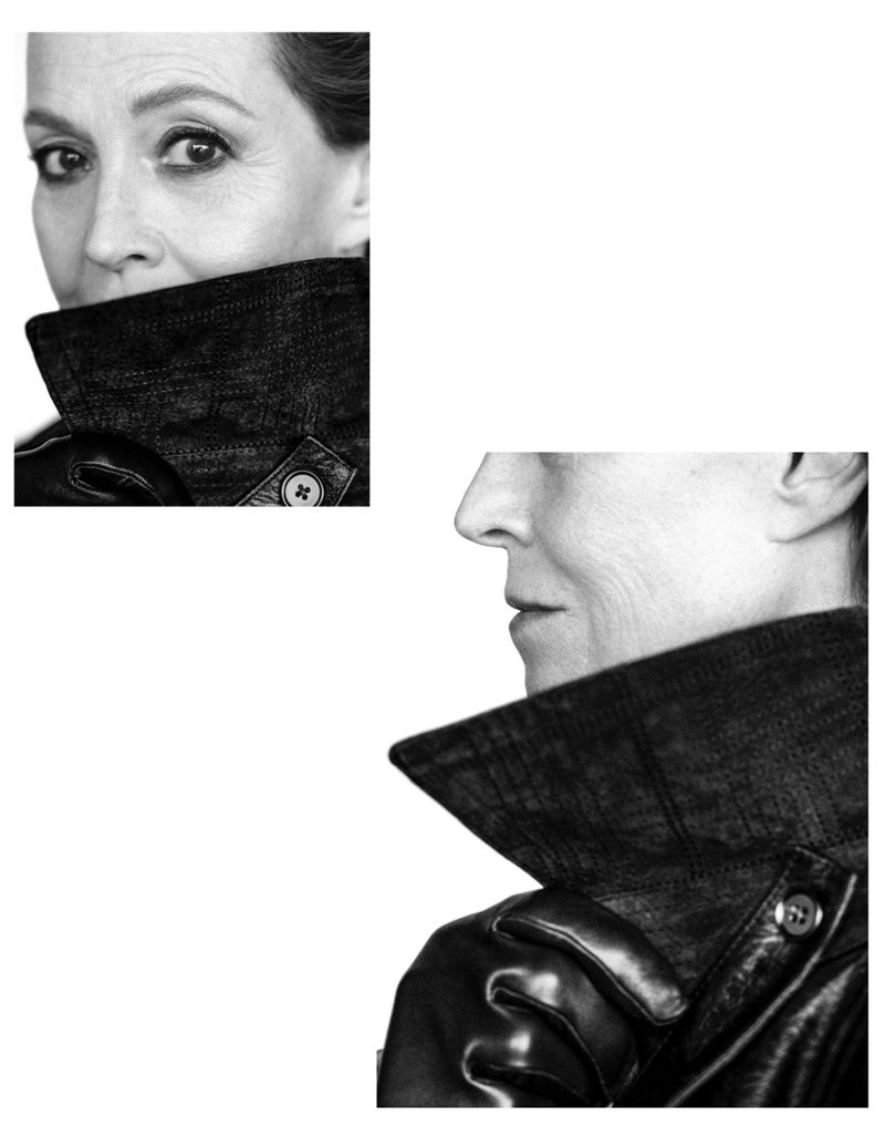Black and white studio portrait of a mature woman in a dark jacket, featuring a close-up of her face and side profile against a white background.