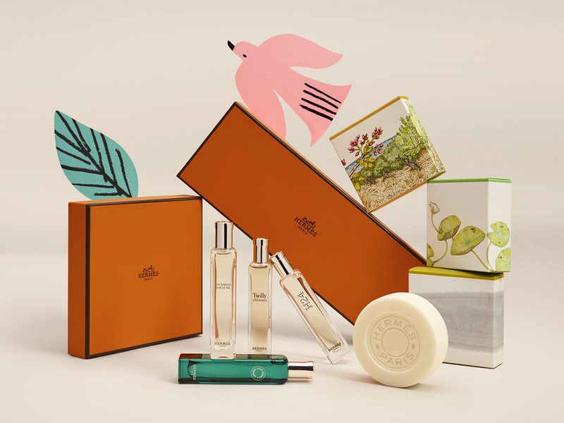Still life of Hermès perfume bottles and boxes, featuring various fragrances in a clean, bright studio setting with soft lighting.