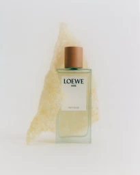 Loewe Aire Anthesis perfume bottle standing upright against a textured translucent material on a white background.