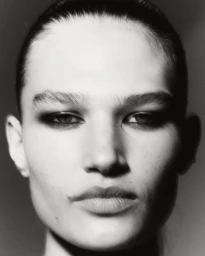 Black and white close-up portrait of model Emmi Freeman with smoky eye makeup looking directly at the camera.