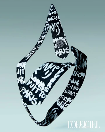 Black and white patterned necktie with 'Louis Vuitton Paris' text and logo floating in the center against a light blue background.