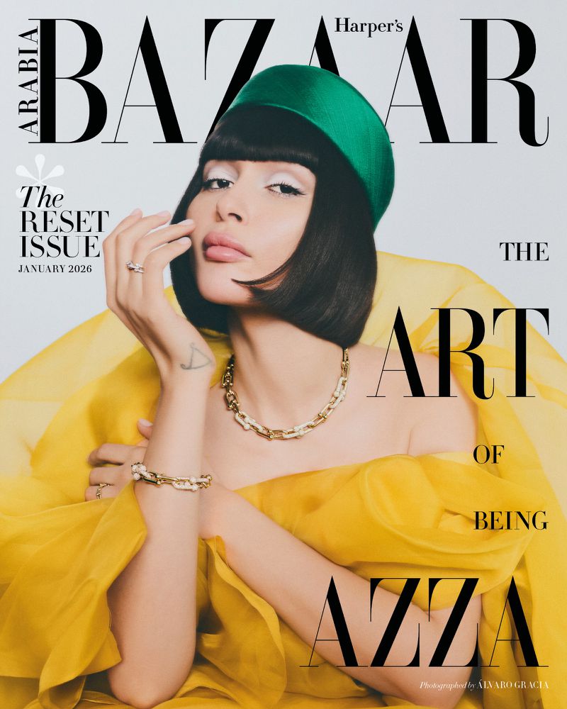 Magazine cover featuring woman with green hat and yellow dress, wearing gold jewelry with white background and black text logo.