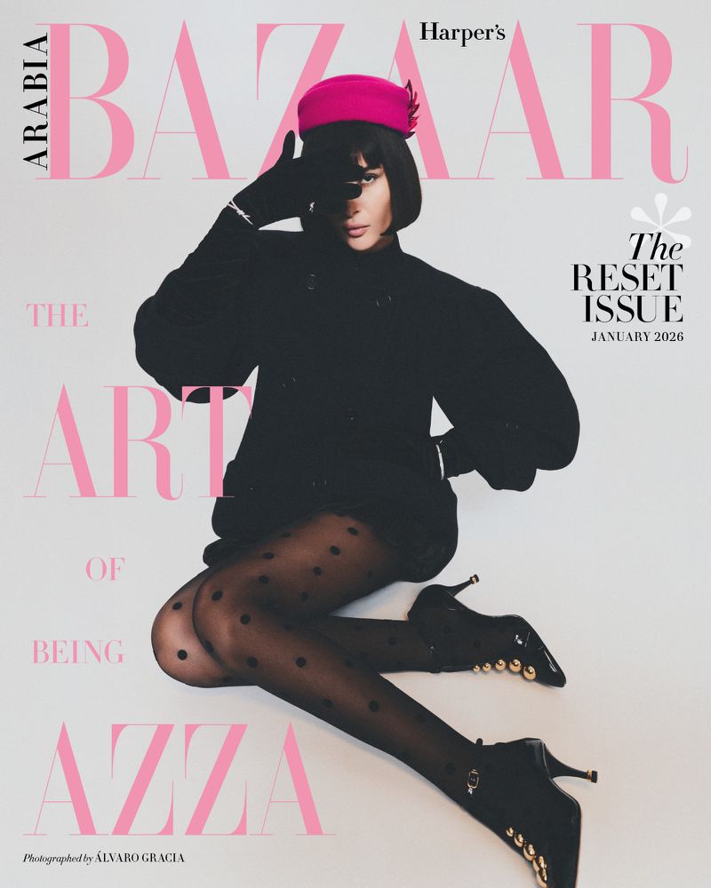 Fashion editorial magazine cover features an adult female model in a black outfit and pink hat, shot in a photo studio.