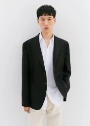 Model wearing a black blazer and white shirt against a plain white background for Massimo Dutti