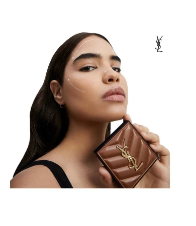 Cosmetic ad features a woman holding a YSL bronzer. The warm lighting highlights her makeup, hair, and beauty product.