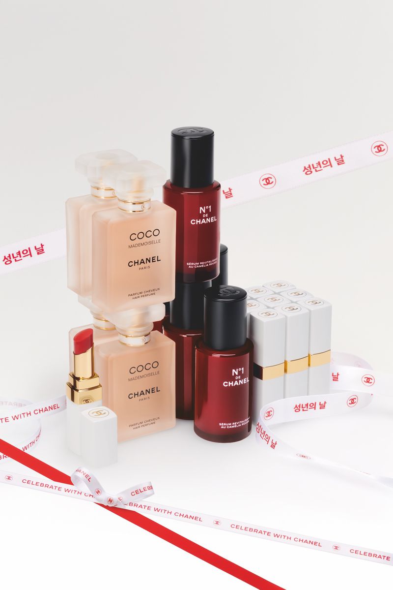 Still life shot of assorted Chanel beauty products including Coco Mademoiselle perfume, No. 1 de Chanel skincare, and Chanel lipsticks.
