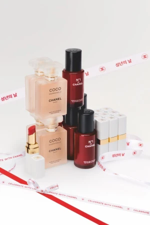 Still life shot of assorted Chanel beauty products including Coco Mademoiselle perfume, No. 1 de Chanel skincare, and Chanel lipsticks.