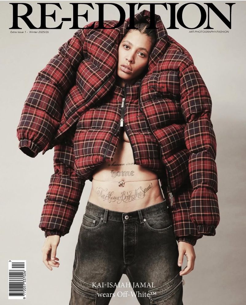 Magazine cover featuring model Kai-Isaiah Jamal wearing a red and black plaid puffer jacket and dark wash jeans against a neutral backdrop.