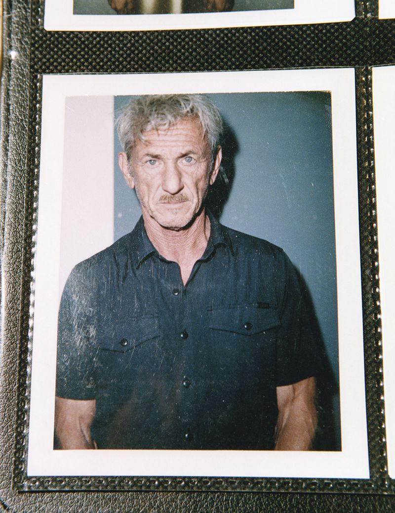 Portrait of an adult man with graying hair and a mustache, wearing a dark blue button-down shirt, captured in a medium studio shot.
