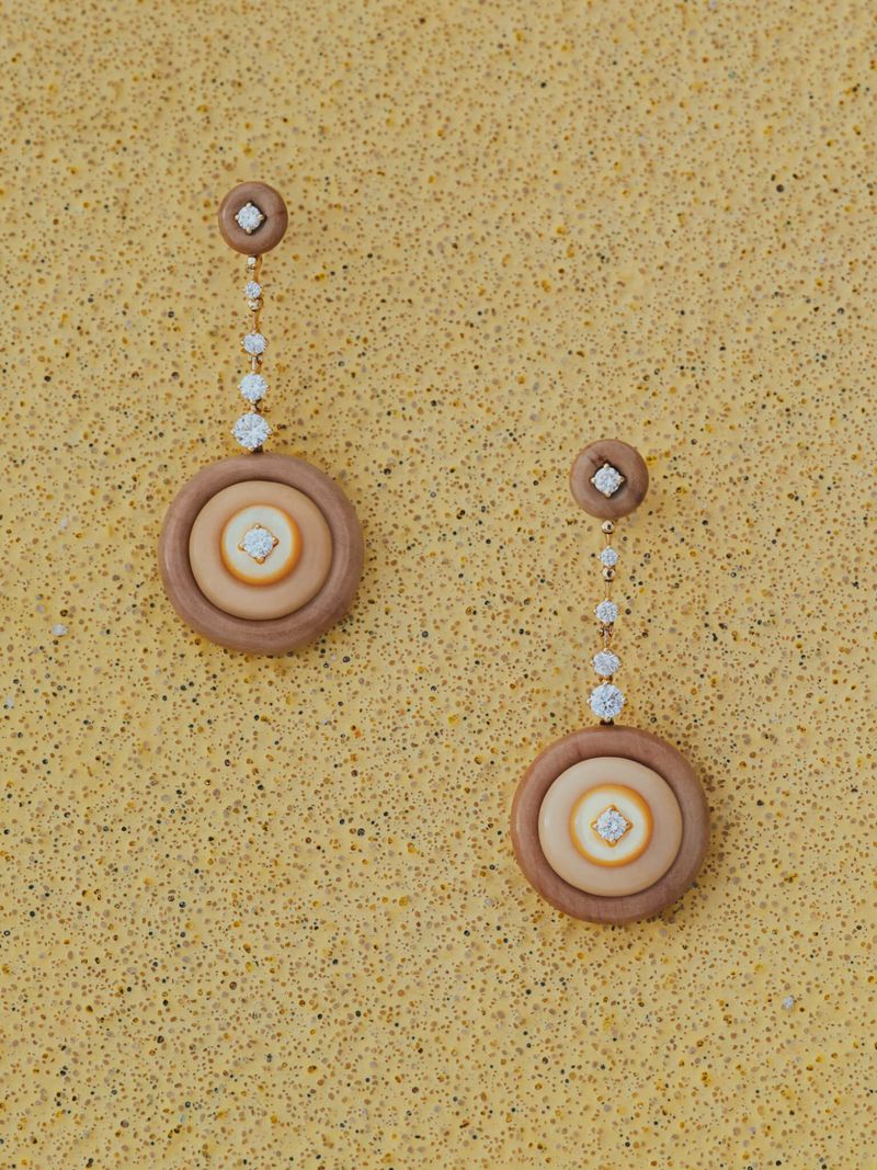 Two wood and diamond dangle earrings on a speckled gold background in a jewelry product shot, designed for earring fashion concepts.
