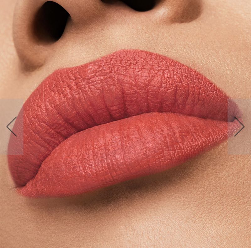 Close-up of a woman's lips with coral lipstick, showing texture and detail. Focus on the lips and surrounding skin.